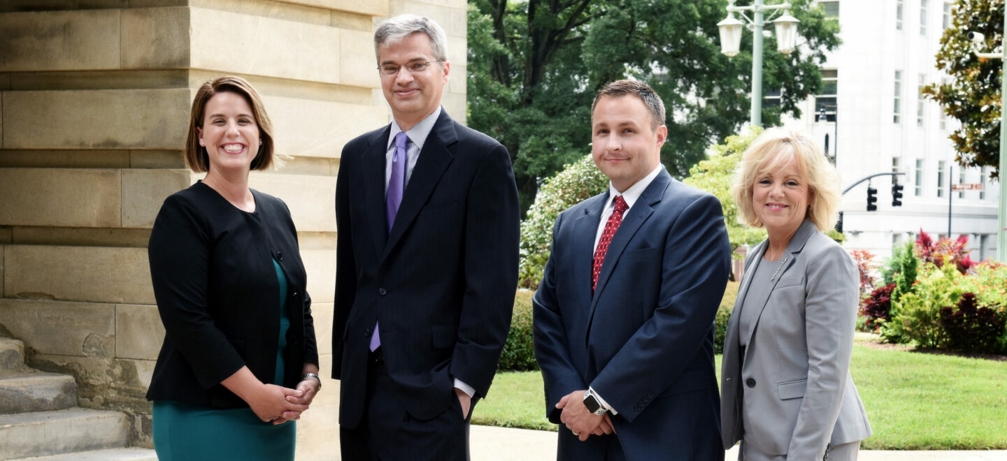 4 lawyers standing near a building