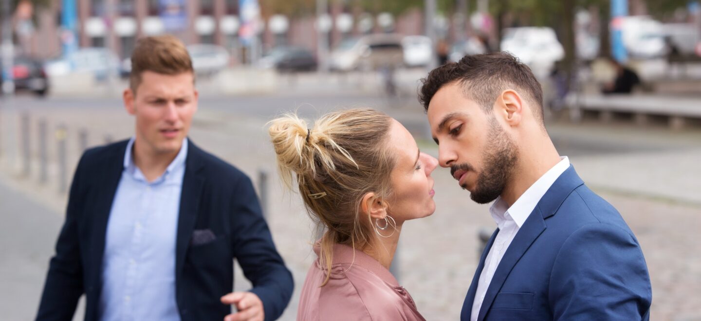 couple about to kiss being stared at by another man