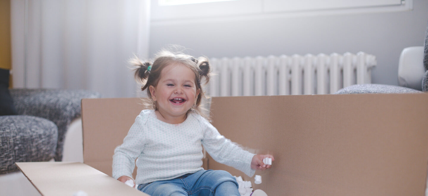 baby girl playing in box with styrofoam pellets