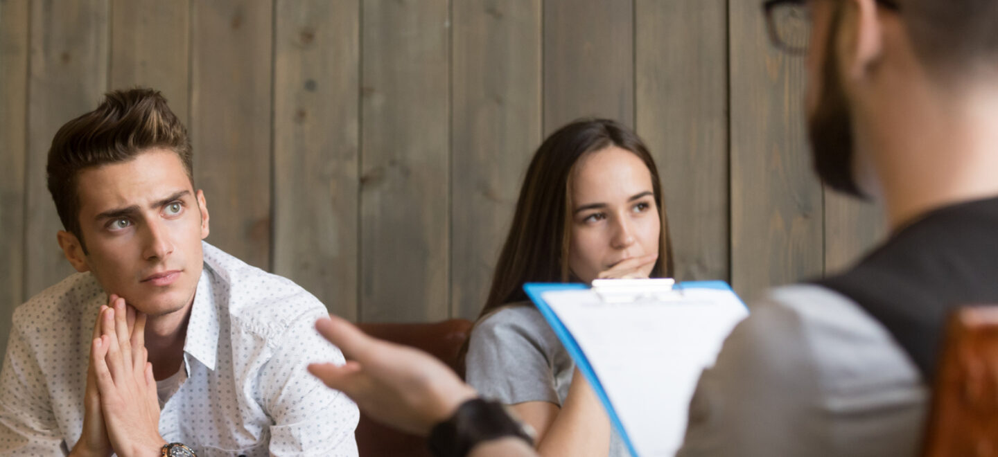 Frustrated worried young man listening to psychologist, couple counseling concept