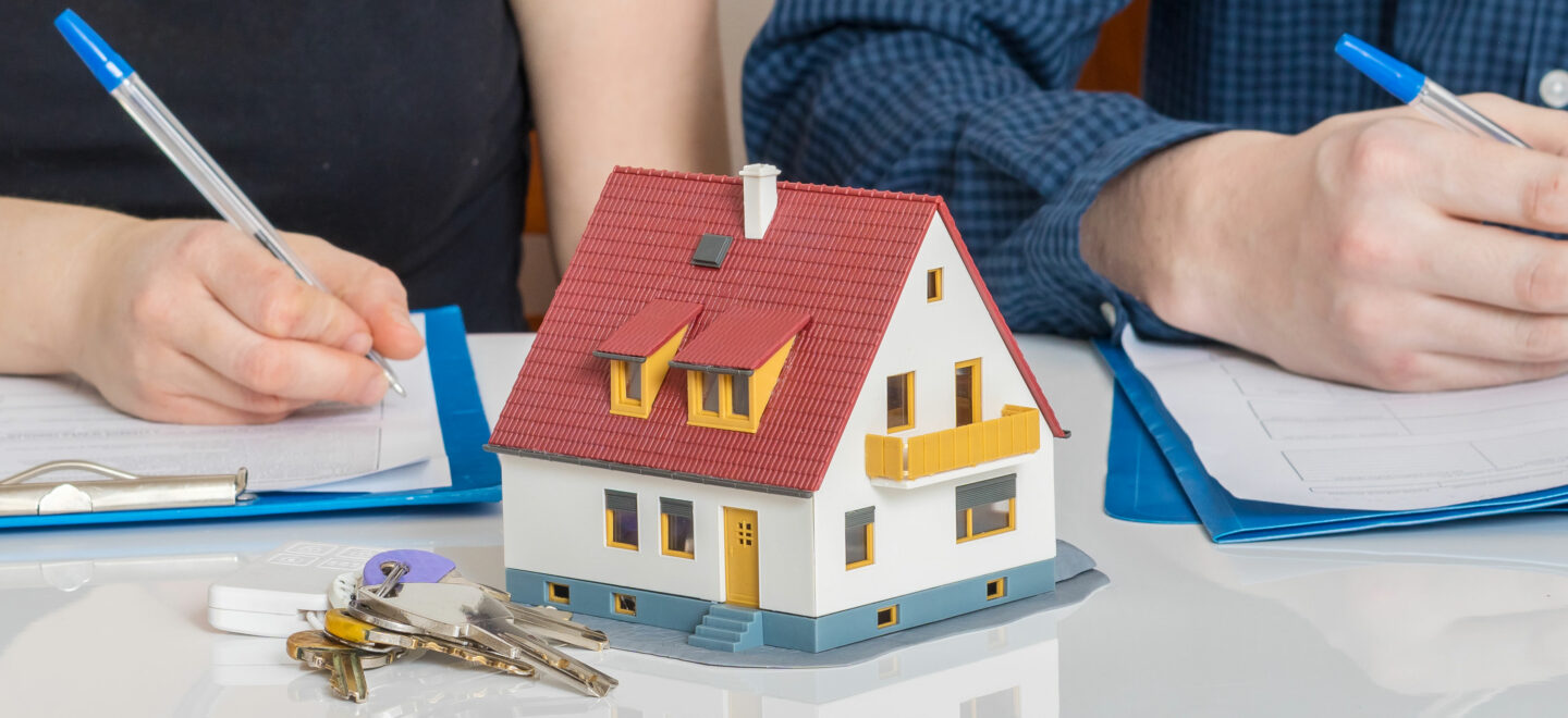 two people writing and small house in foreground